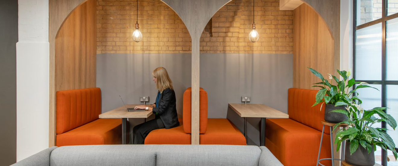 Bright workspace with warm colours, comfortable booths and plants