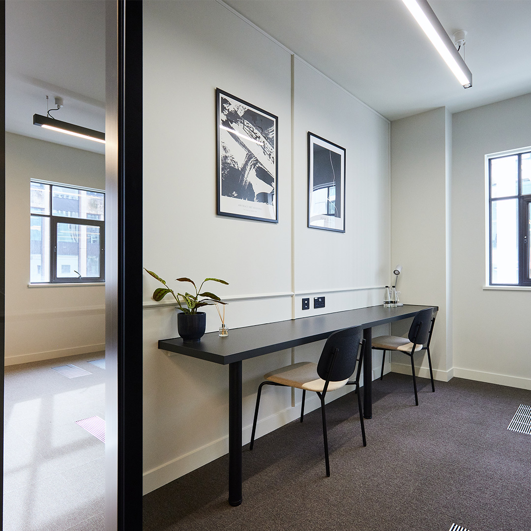 Sleek conference zoom room in a minimalist office interior design featuring wall beading and sunlight
