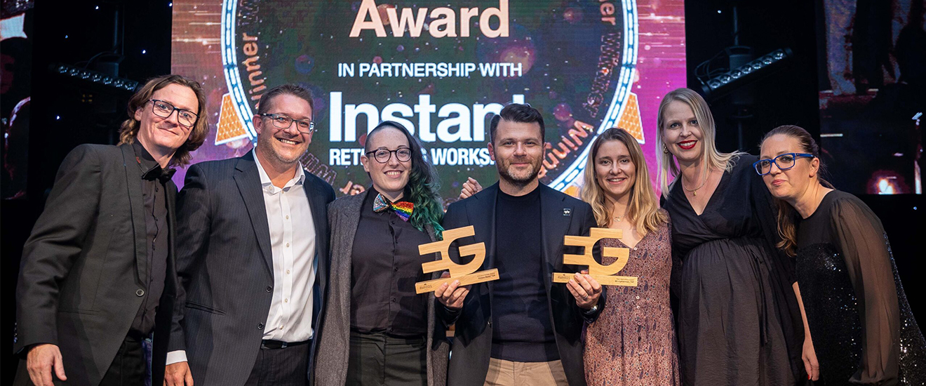 Colleagues on stage at a ceremony accepting an award