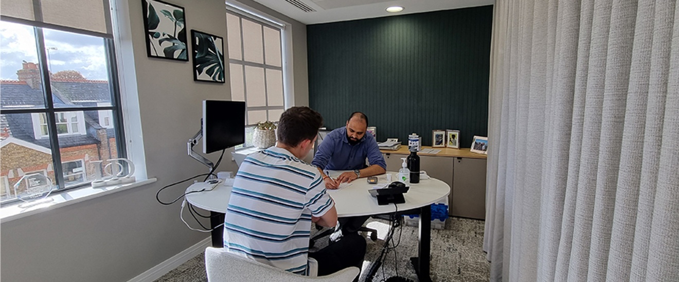 man getting his blood pressure tested by a GP in a private office