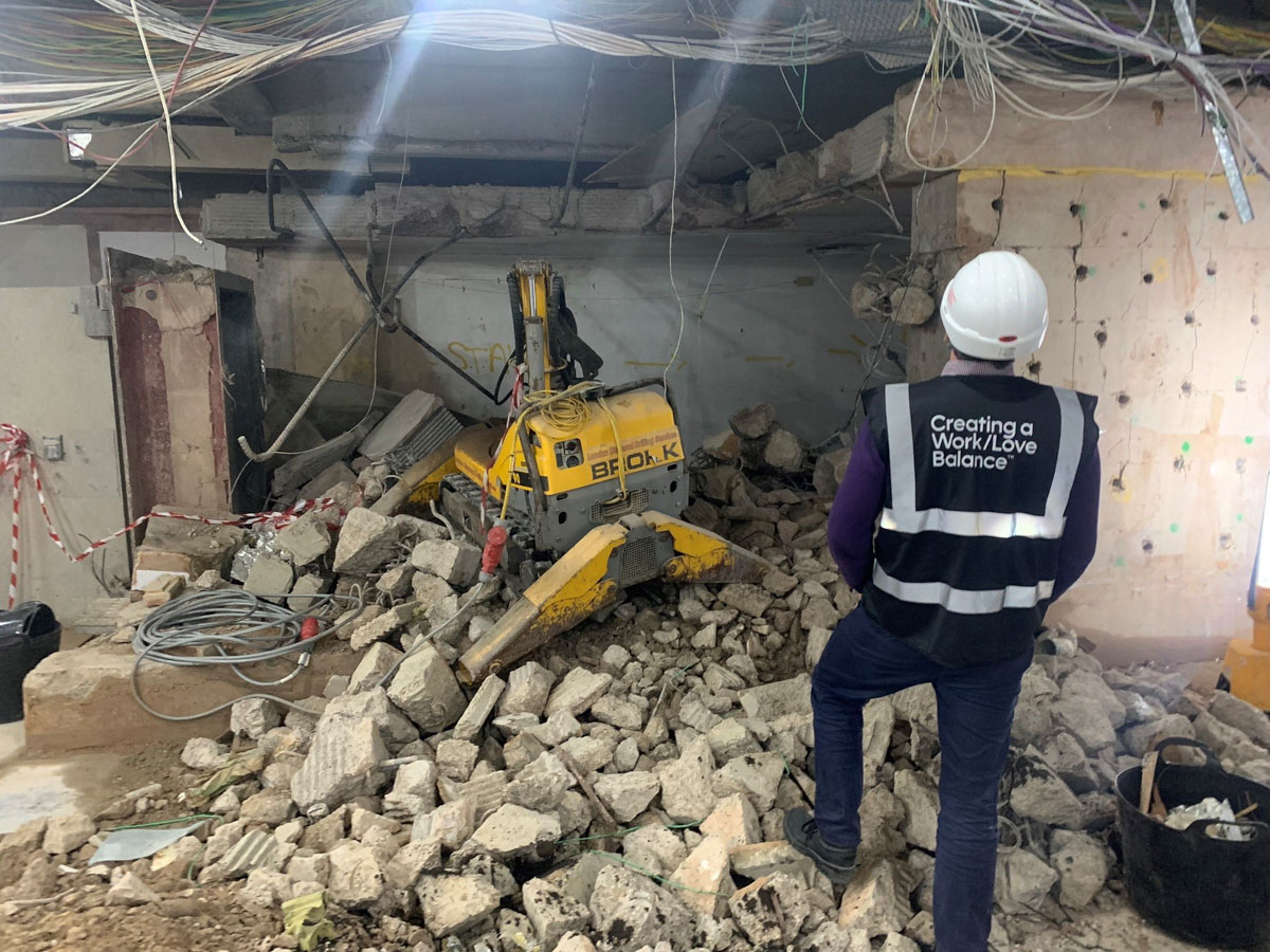 Man in PPE on construction site with rubble