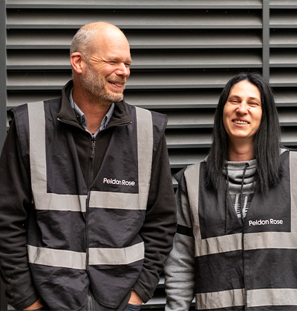 Two site managers laughing with each other, one man and one woman