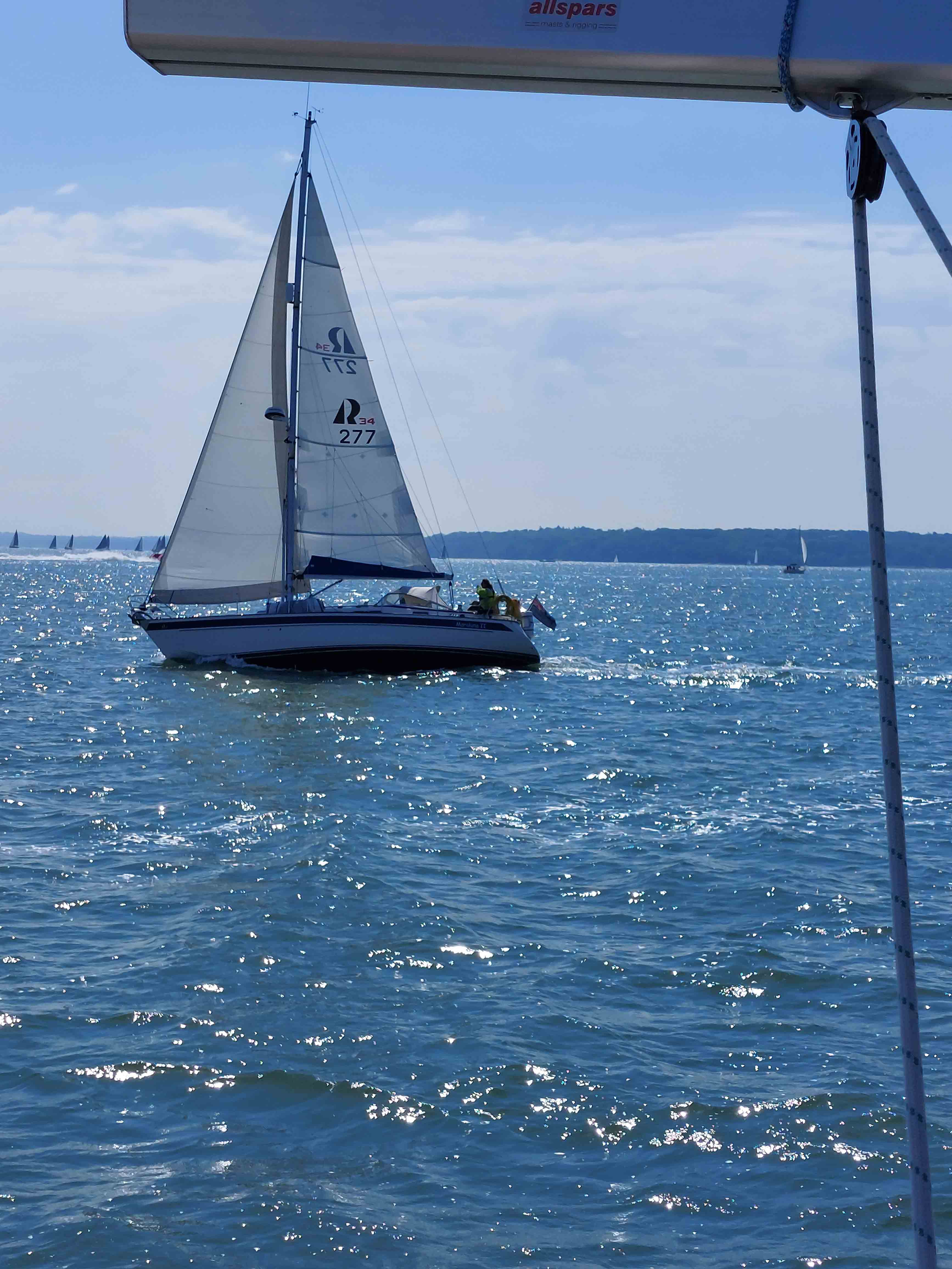 A sail boat out on the water on a sunny day.