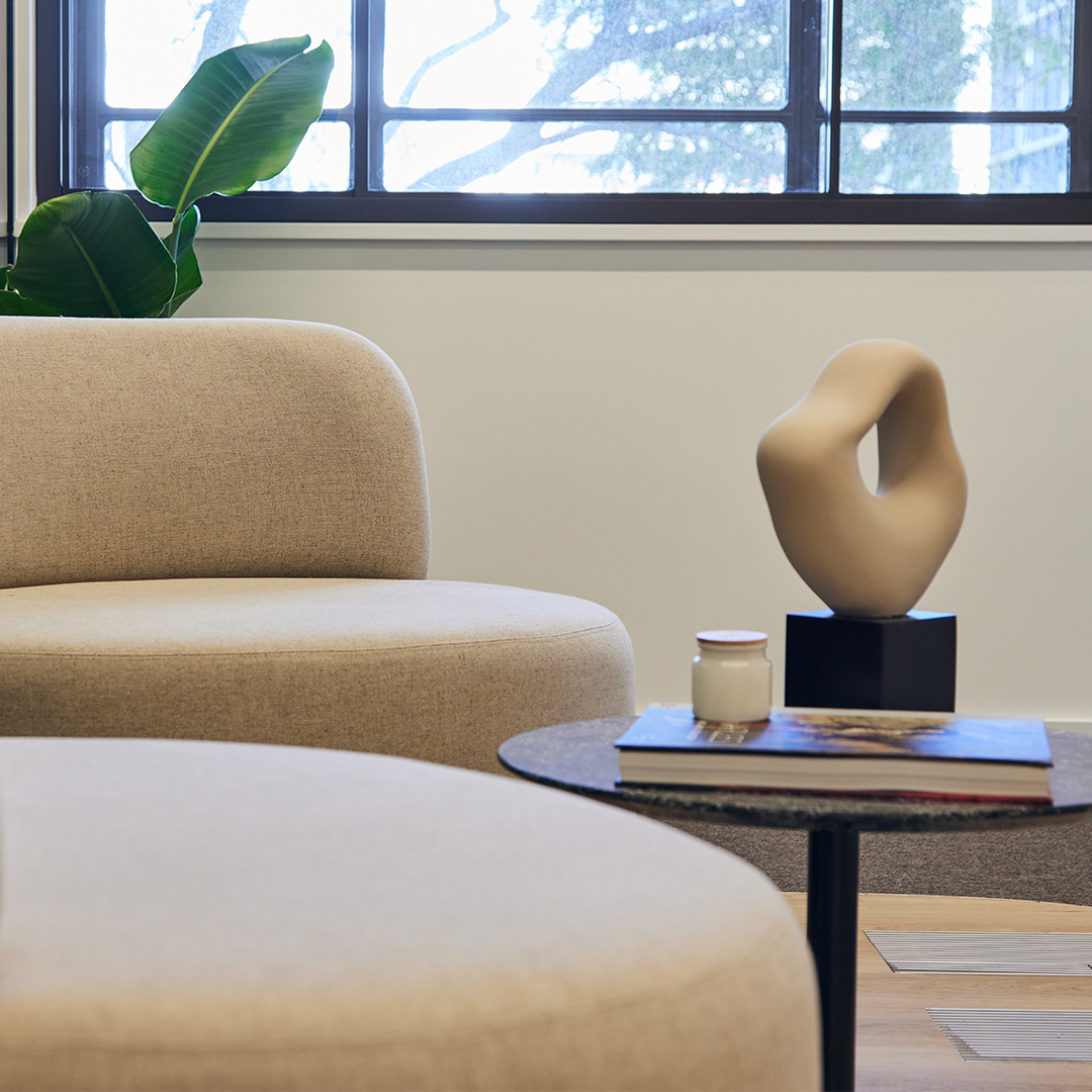 The image is a close up shot of two comfortable chairs and a coffee table, in the arrival area of an office