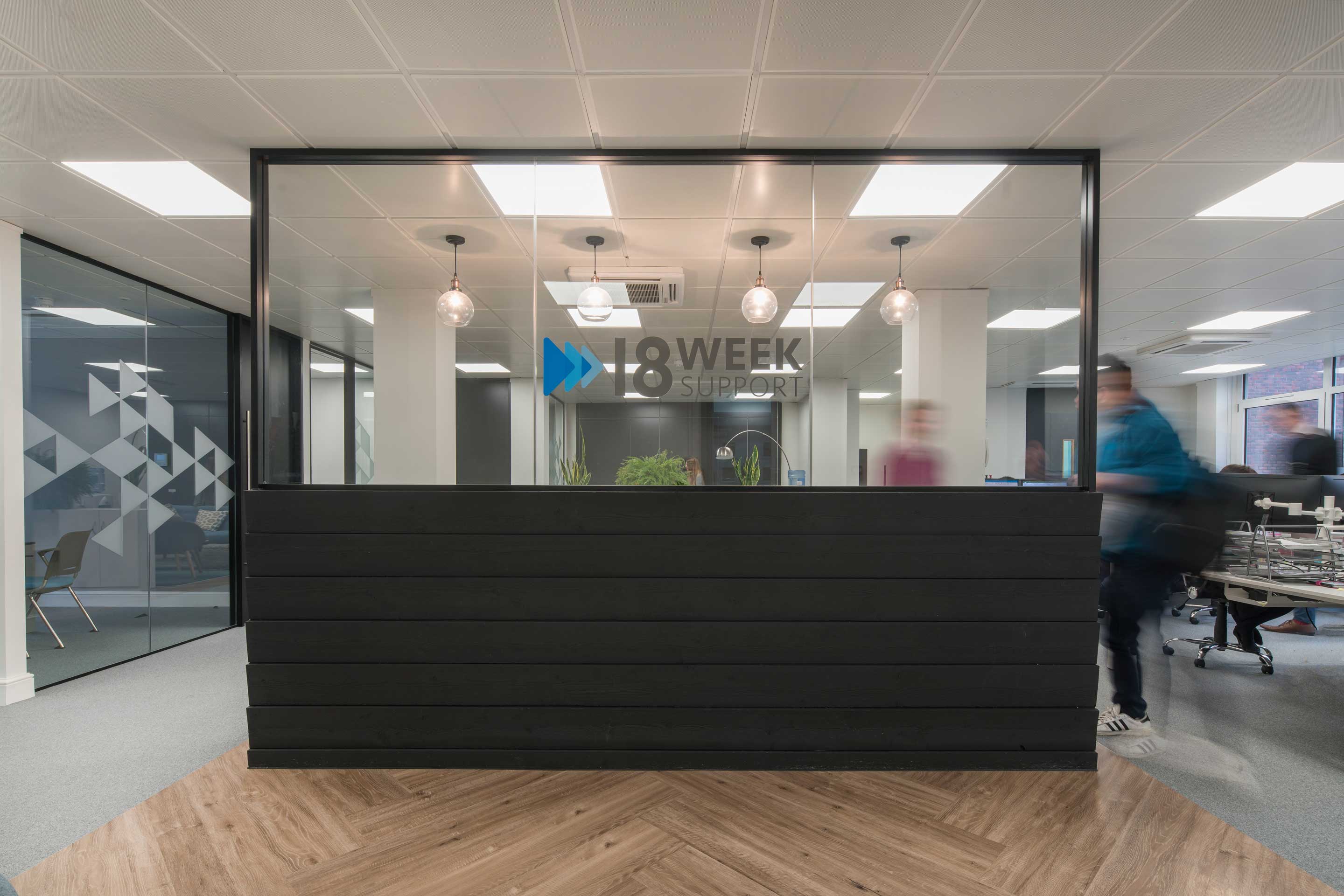 an open office environment with a black and glass wall divider