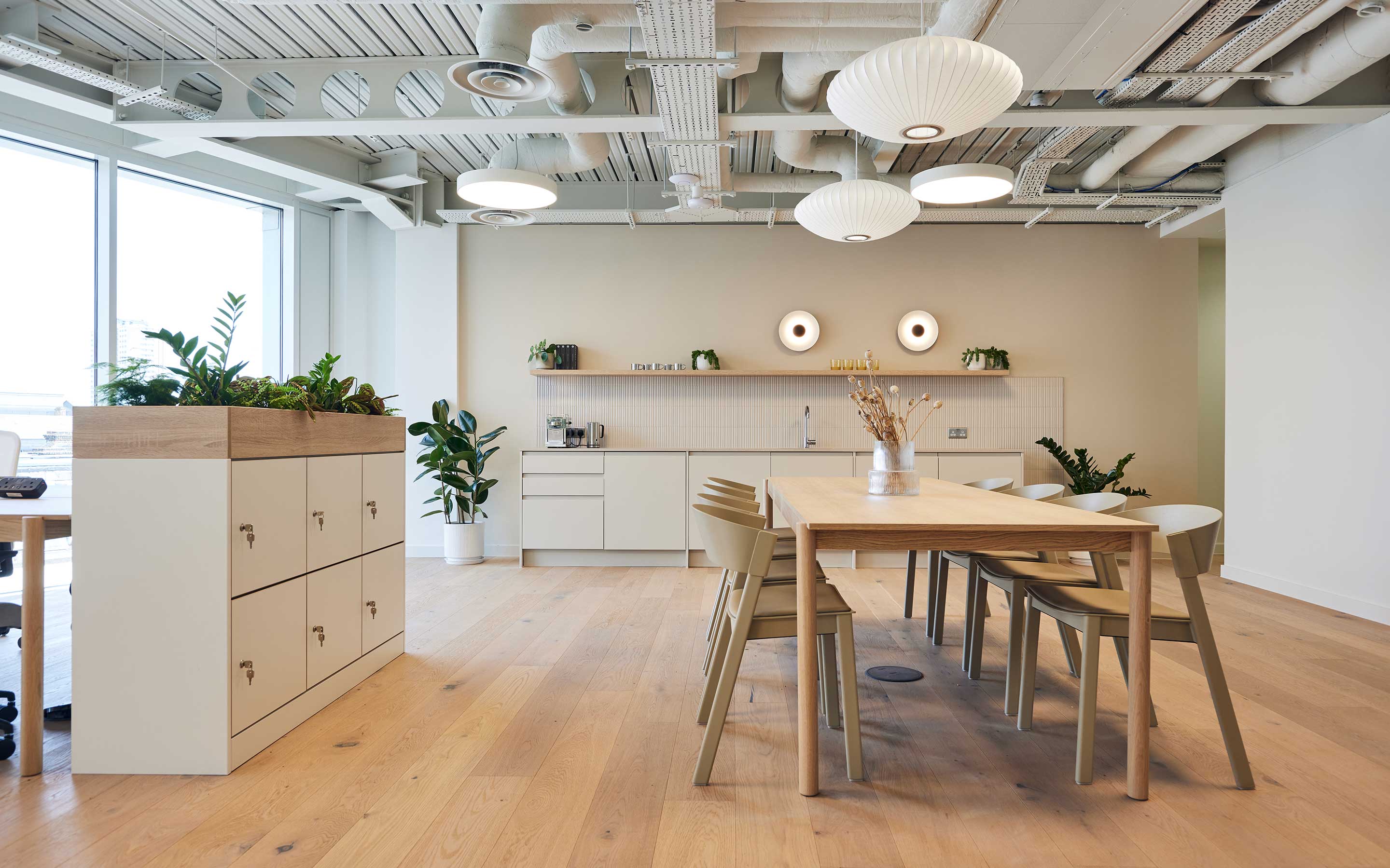 A modern office kitchen area complete with natural wood materials, light finishes and a calming atmosphere