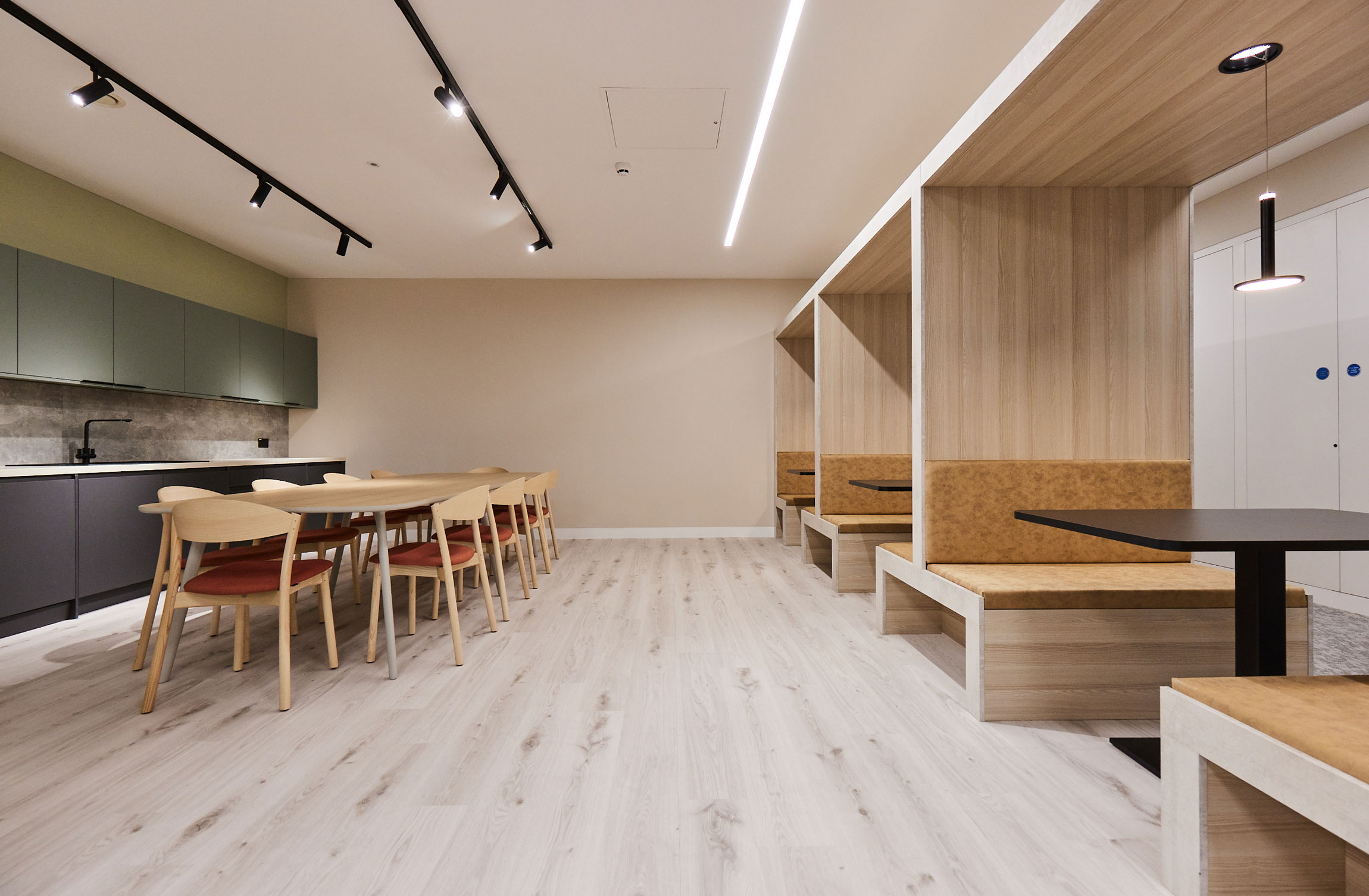 A kitchen and tea point is home to a large kitchen table and several collaborative meeting booths