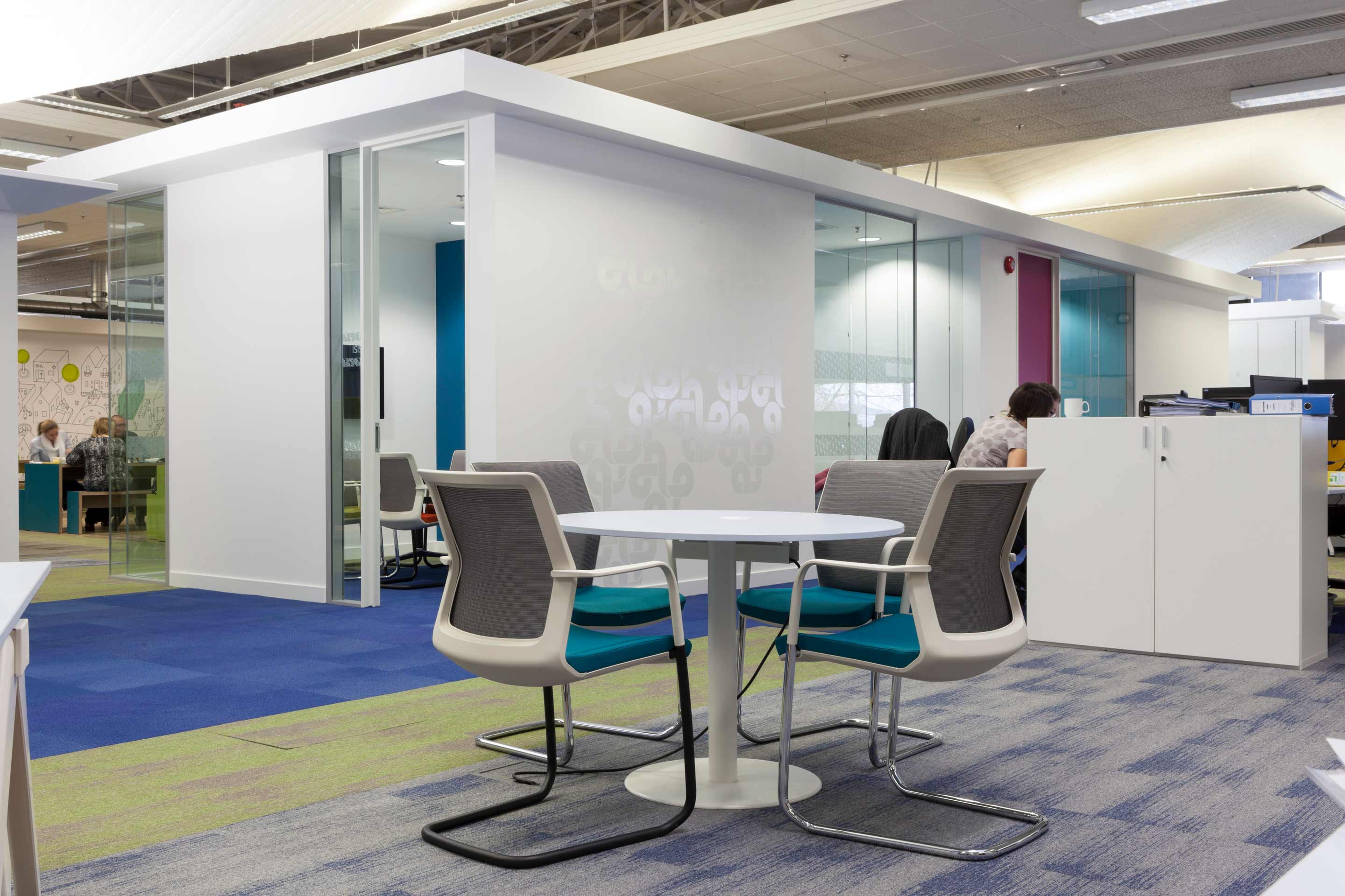 A white table and chairs situated in an open place office space