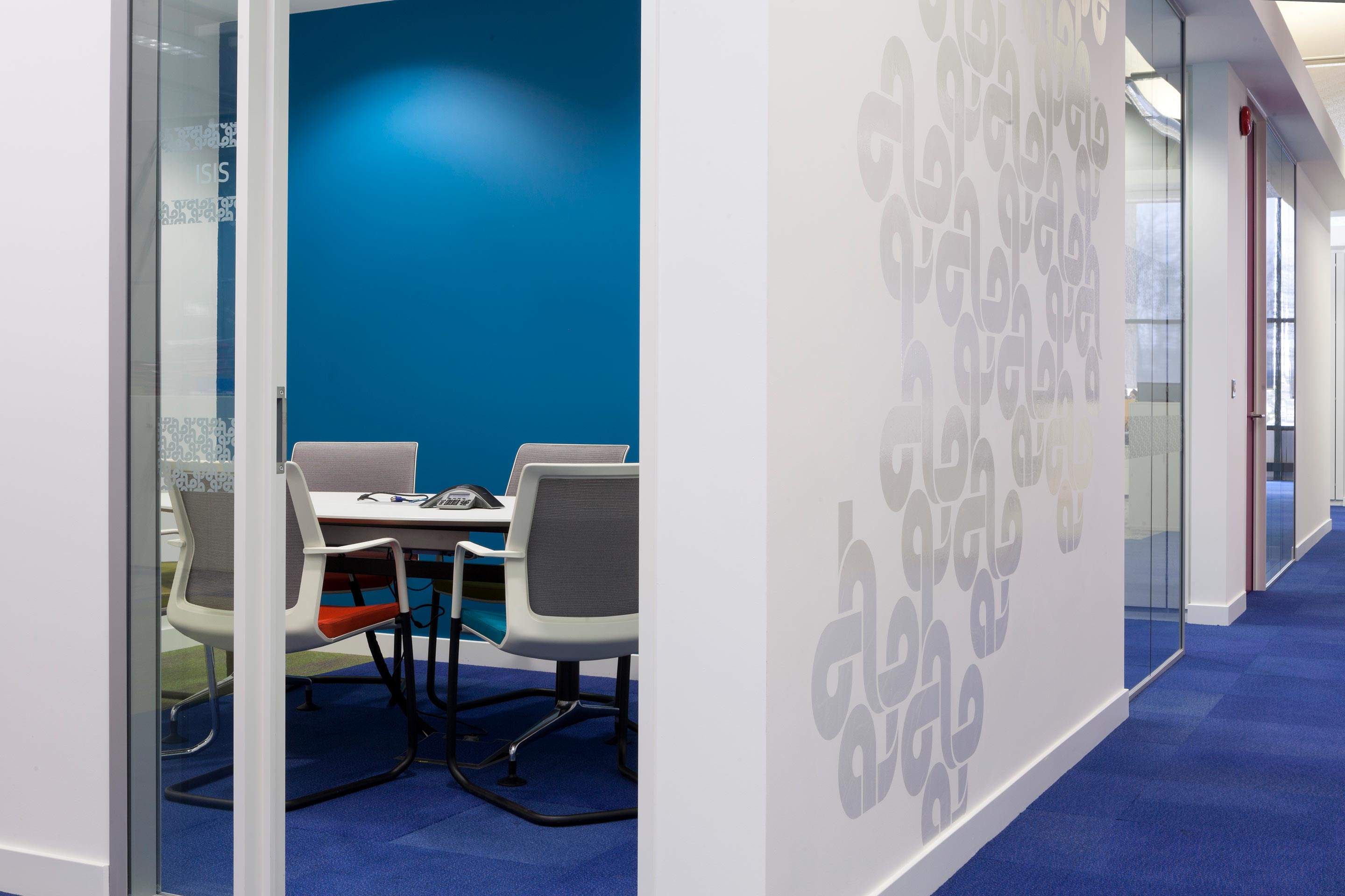 An inside view of a blue meeting booth with a white table and chairs