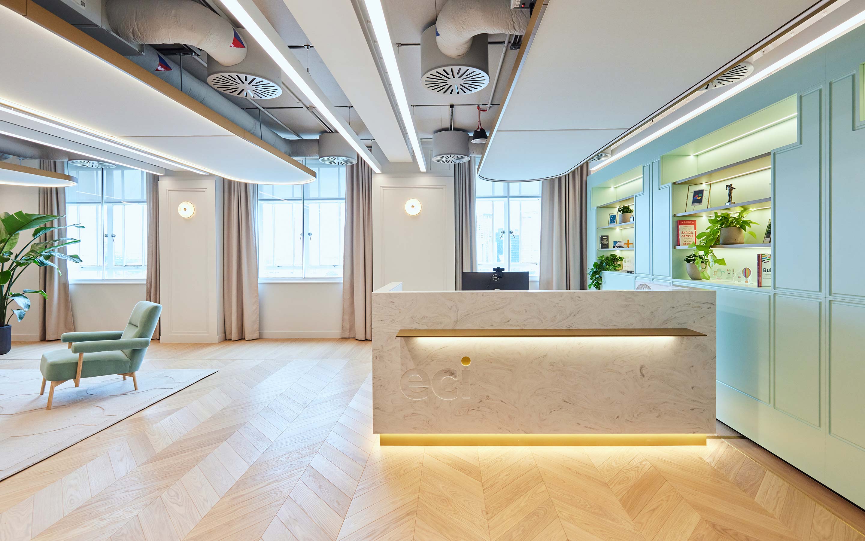 Marble reception desk and a new build office. The desk sits next to a pale blue feature wall.