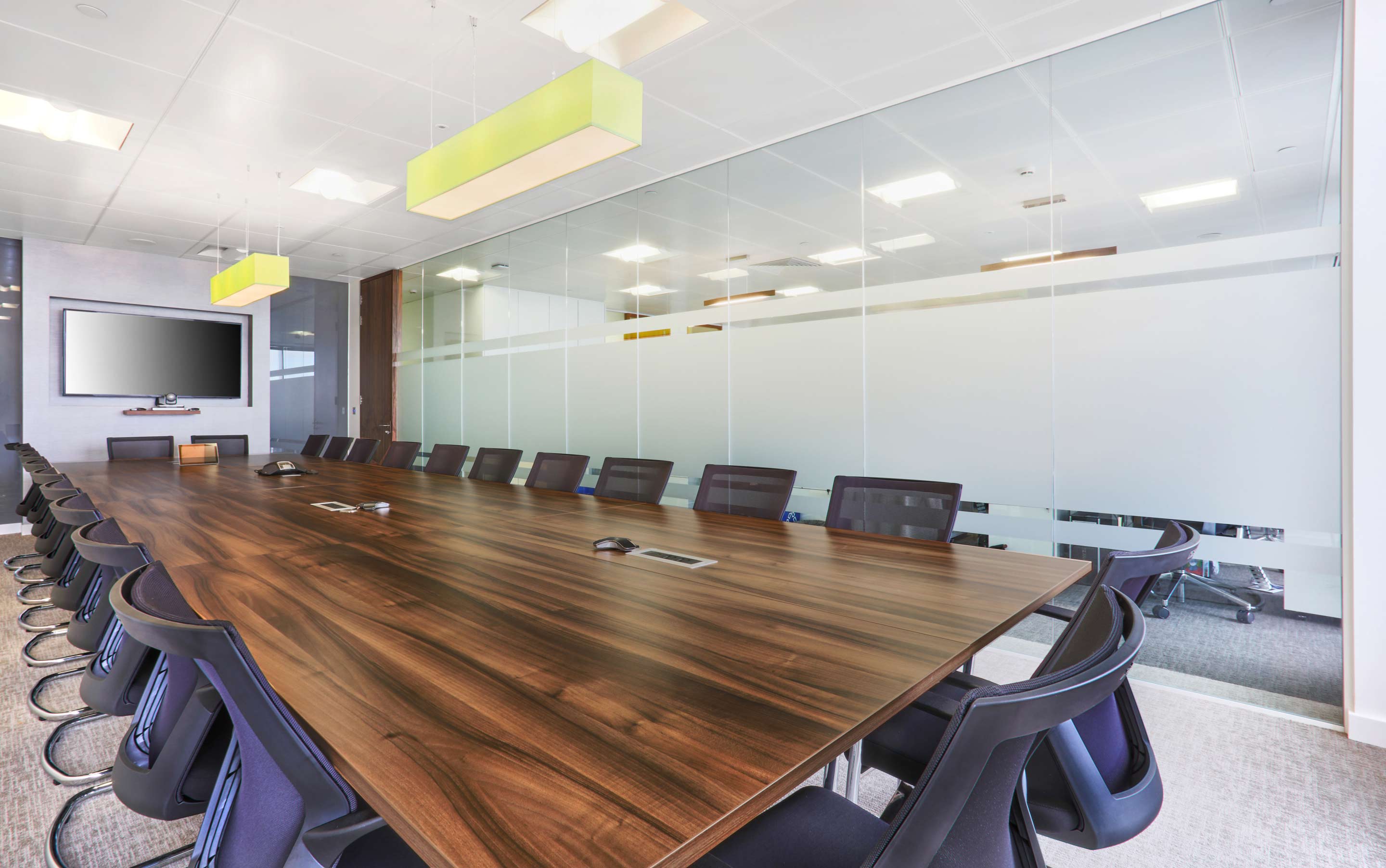 Boardroom with a glass wall and a dark wooden rectangle table