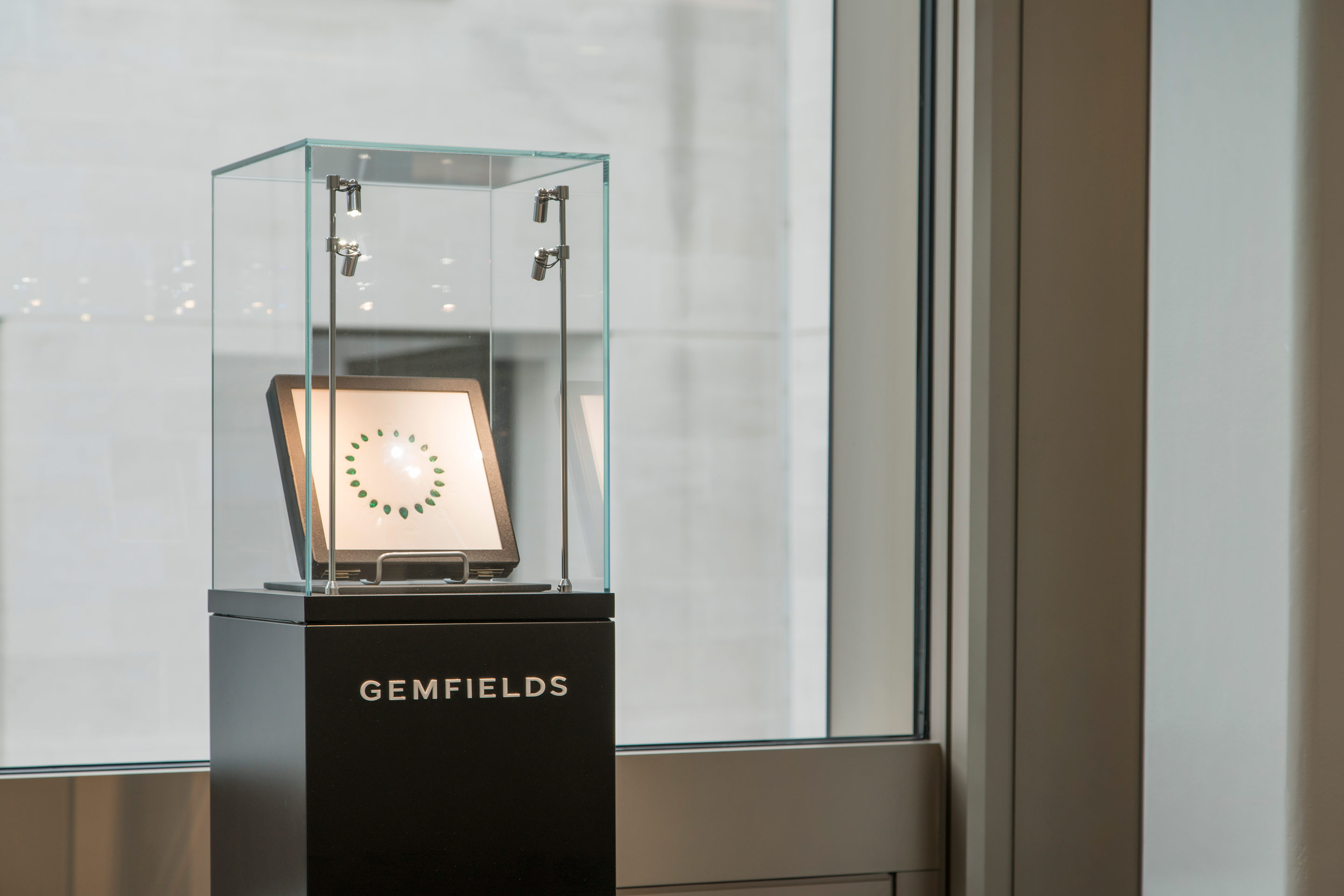 Green Gem stones encased in a glass box