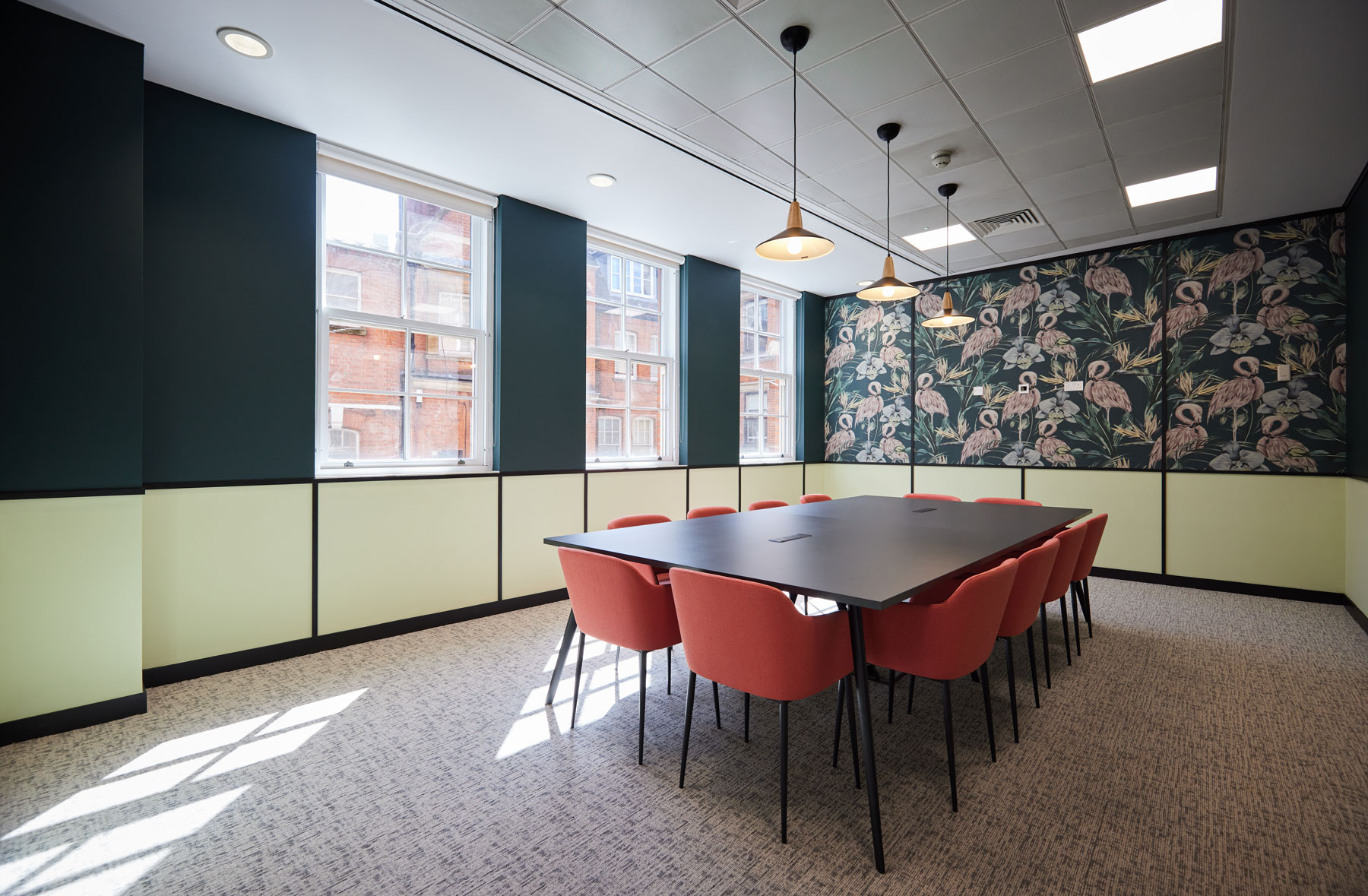 Boardroom with pink soft meeting chairs and flamingo wallpaper