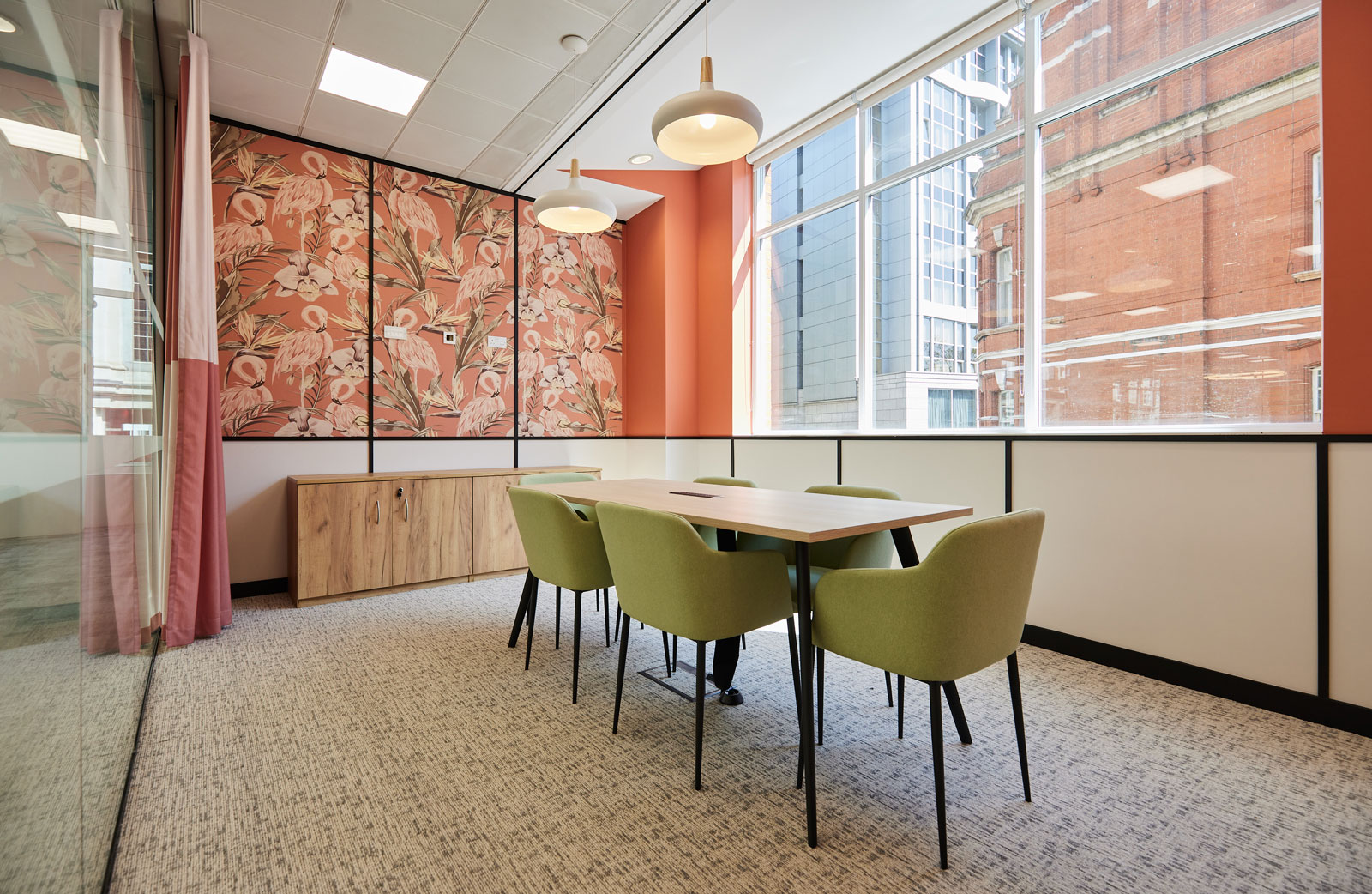 Meeting room with soft seating and pink flamingo wallpaper