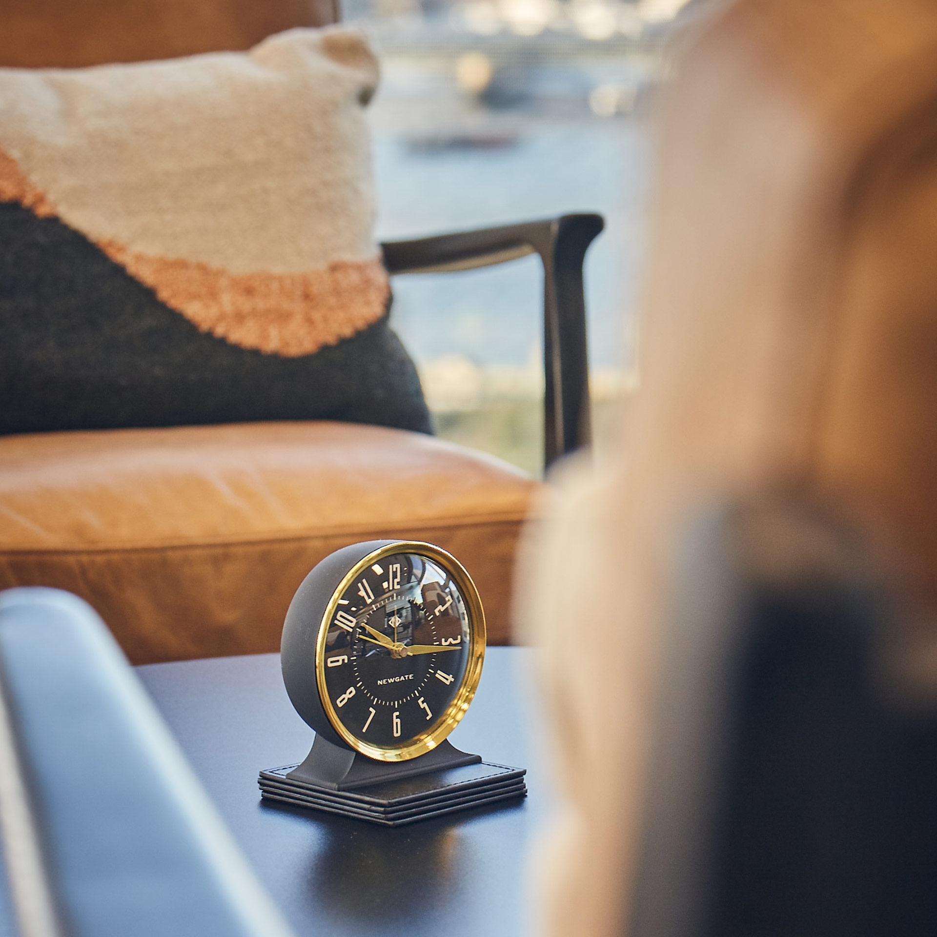 clock ornament on coffee table with colourful cushion in the background