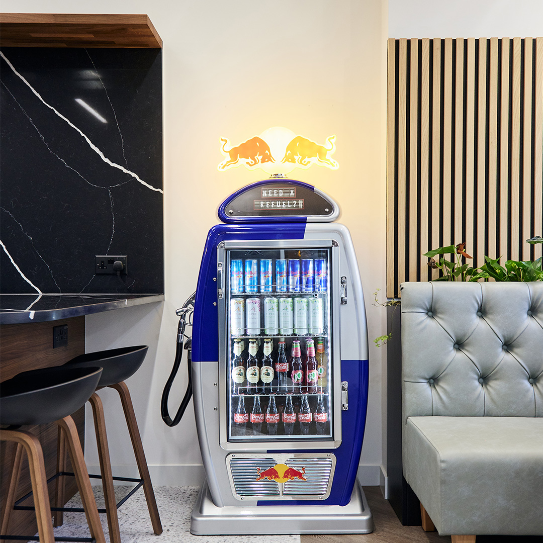 Office interior design showcasing breakout seating and a bespoke drinks cabinet inspired by the motor industry and red bull