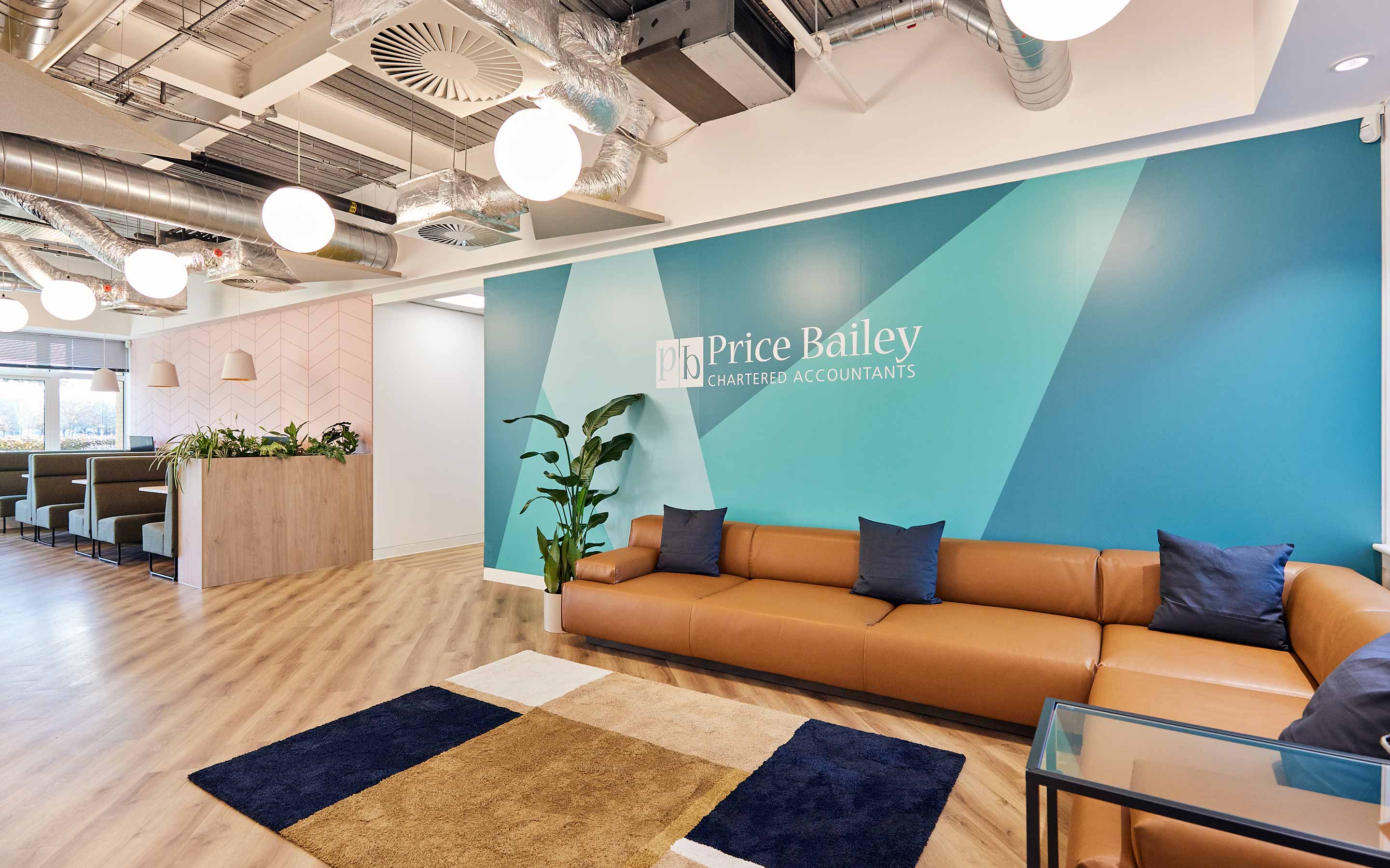 A professionally designed office interior with a focus on workplace functionality and an attractive reception area with blue walls and brown sofas