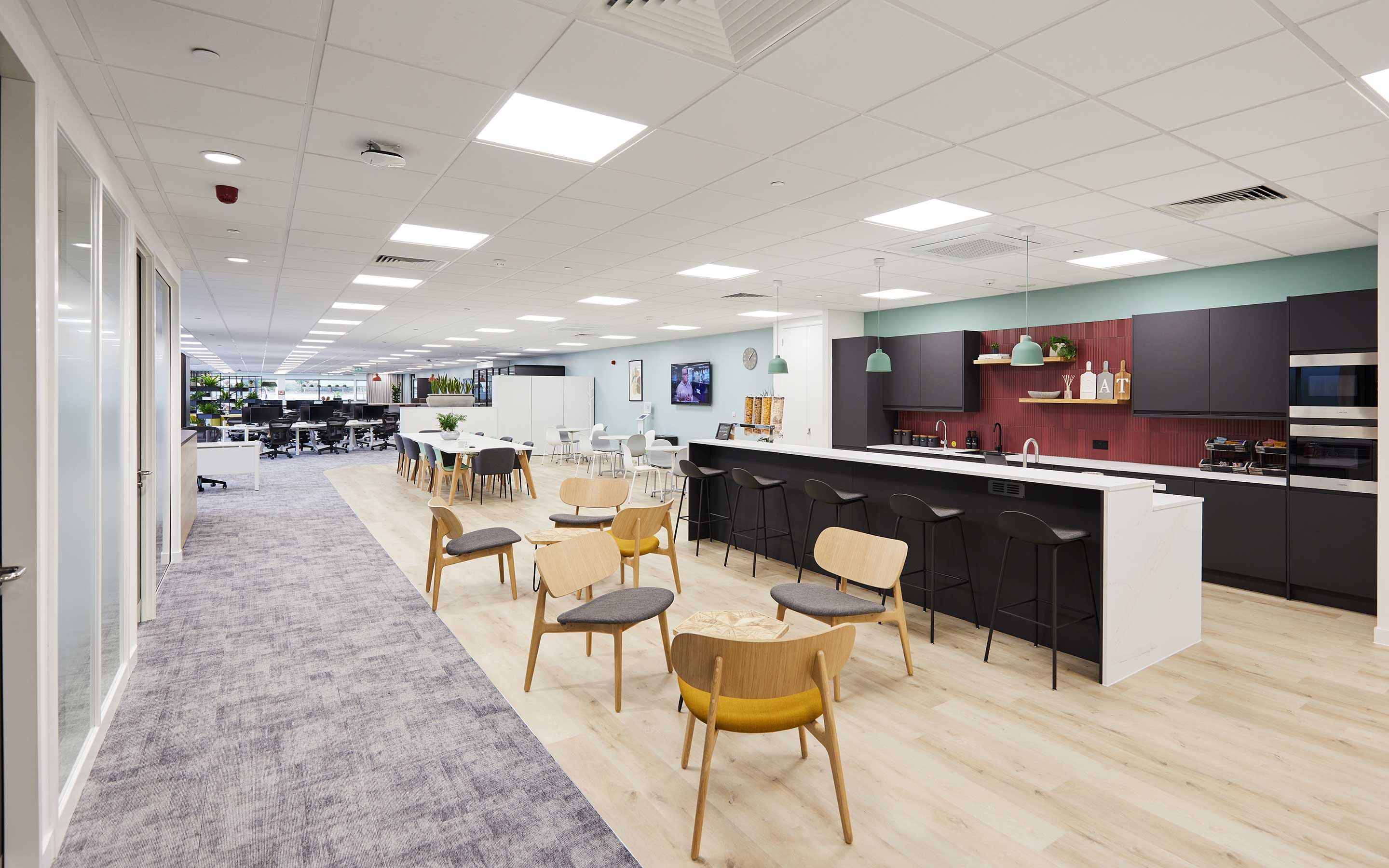 The view shows an office tea point area with a breakfast bar, tables and chairs, and coffee making facilities