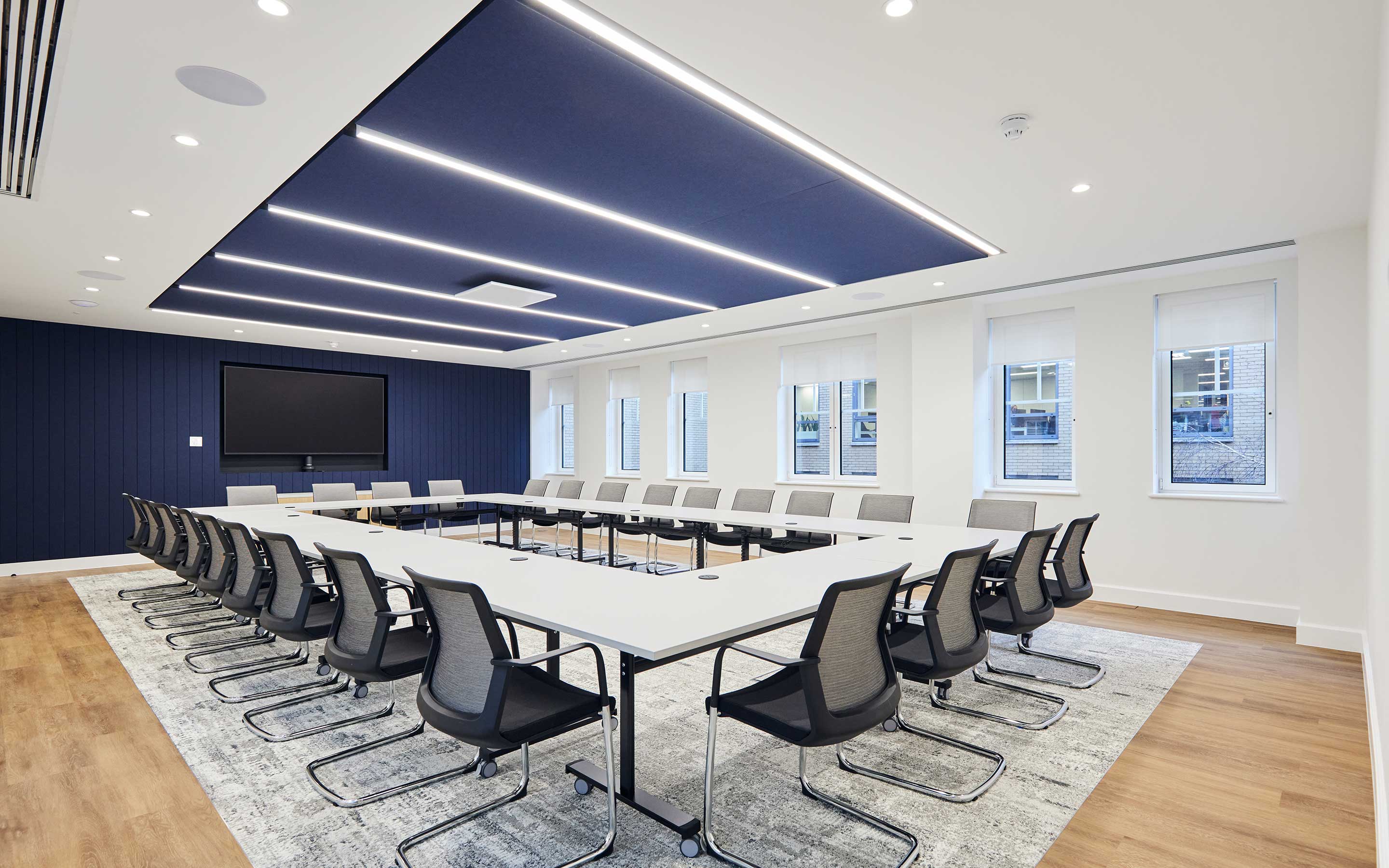 A large boardroom with optimised acoustics, AV and lighting, characterising a sleek and modern office interior design