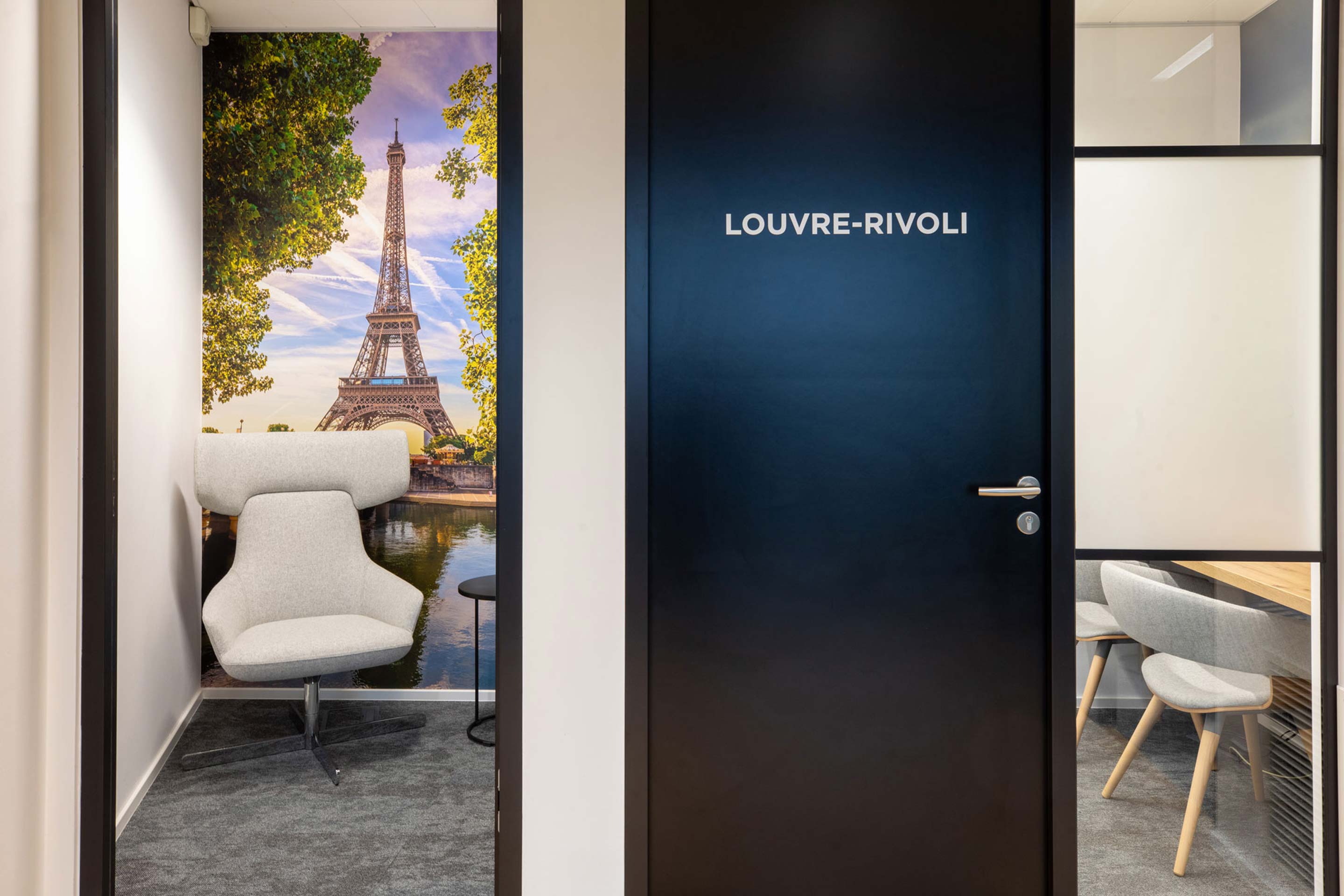 Two small meeting rooms with soft seating and Eiffel Tower on the wall