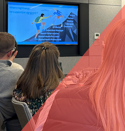 Group of people attending a mental health seminar looking at a screen