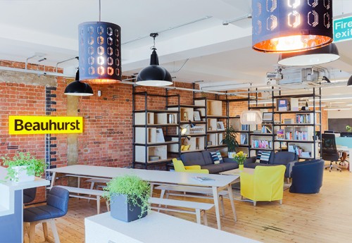 A social seating area with a bookshelf and an exposed brick wall