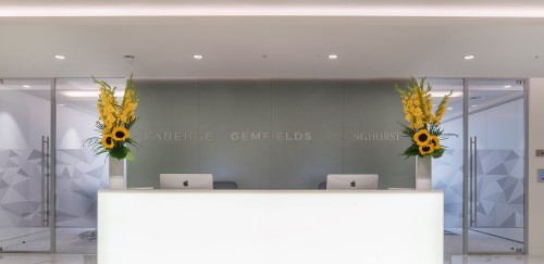 white and grey front desk with sunflowers and macs