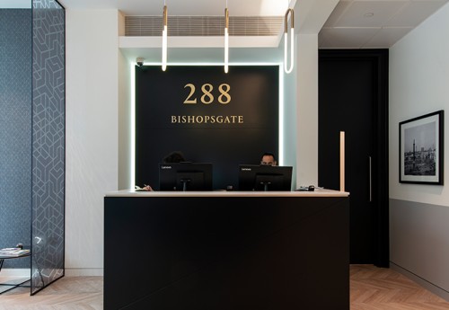 front desk reception area with tube lighting and gold lettering