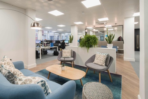 blue and grey social seating area surrounded by white deskspaces